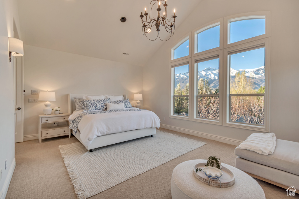 Bedroom with high vaulted ceiling, a chandelier, light carpet, a mountain view, and baseboards