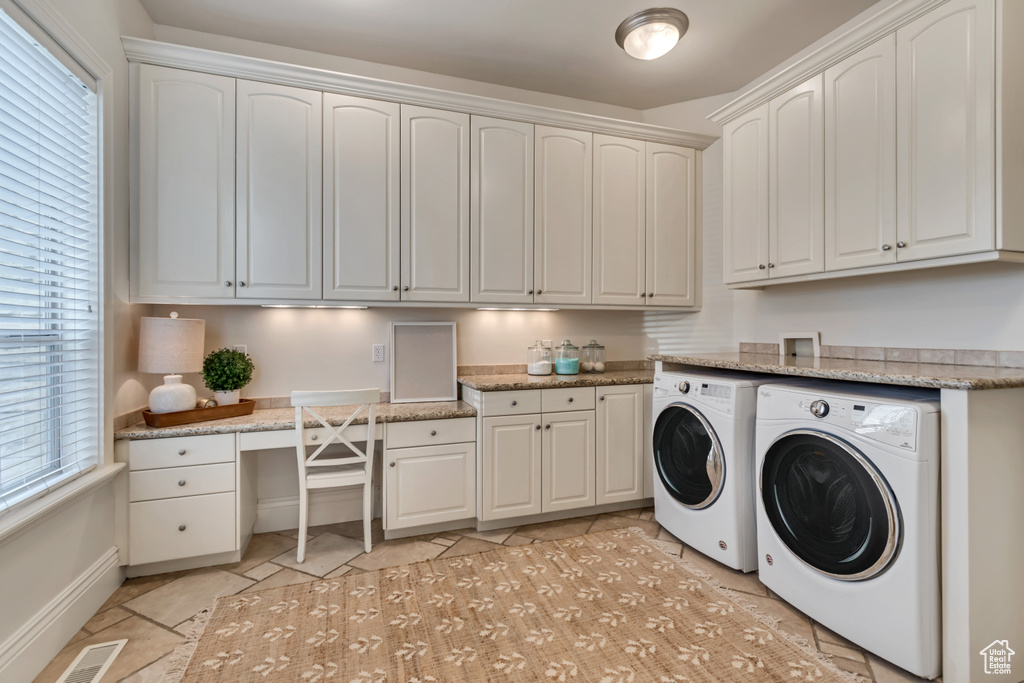 Laundry area featuring visible vents, baseboards, light tile patterned floors, cabinet space, and washing machine and clothes dryer
