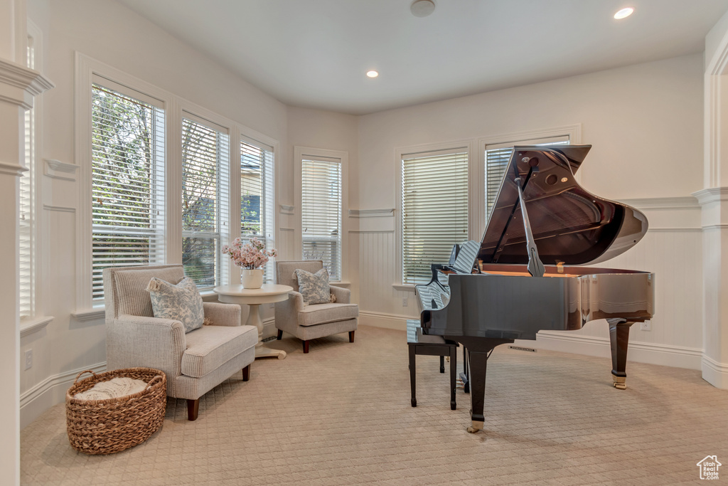 Sitting room featuring a decorative wall, carpet flooring, wainscoting, and recessed lighting