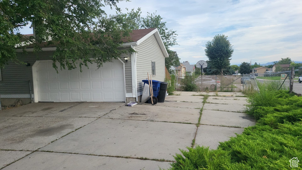 View of side of home with a garage and fence