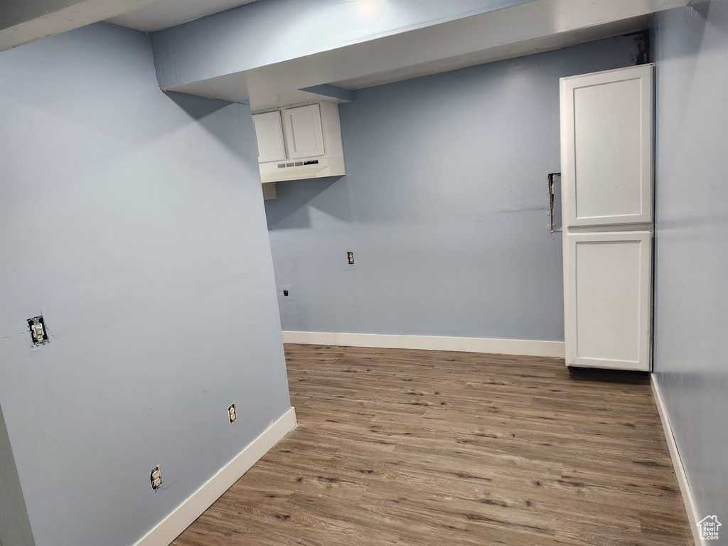 Washroom with baseboards and wood finished floors