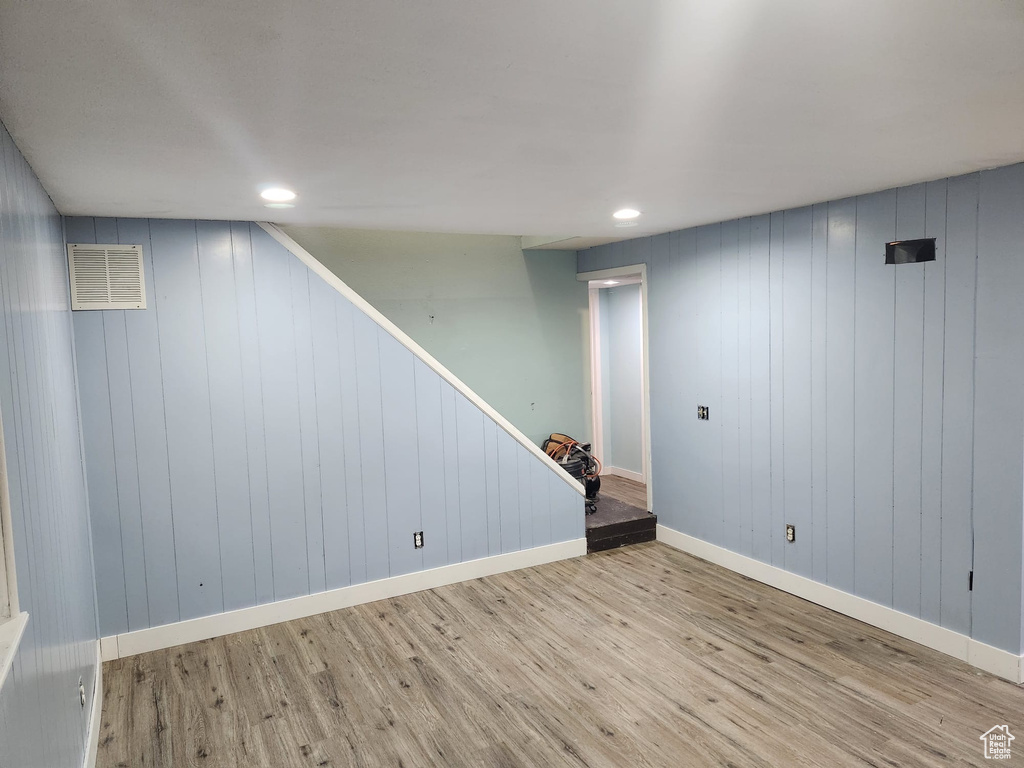 Finished basement with visible vents, recessed lighting, wood finished floors, stairs, and baseboards