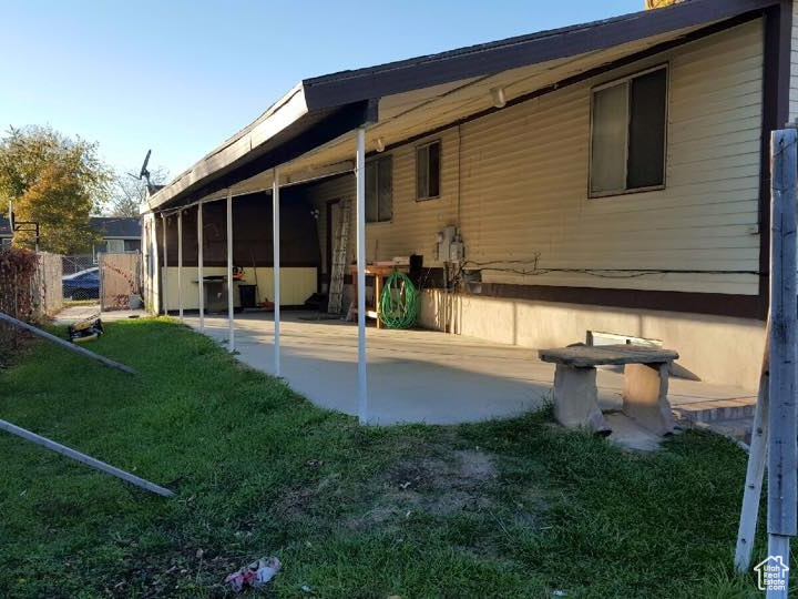 Back of house with a patio area, fence, and a lawn