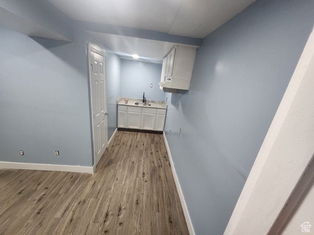 Bar with baseboards, a sink, and wood finished floors