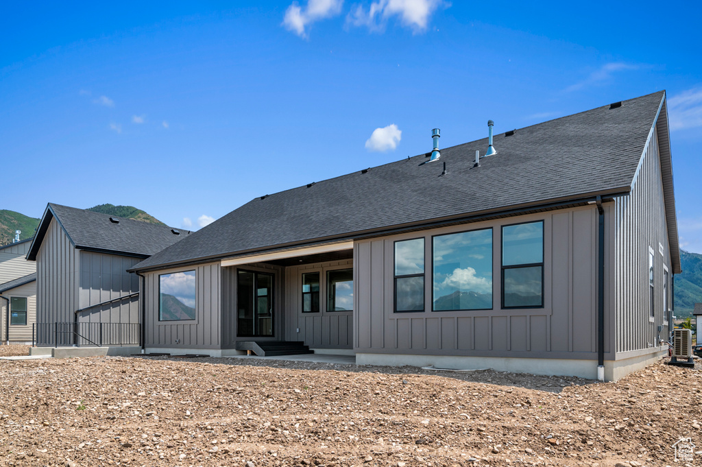 Back of house featuring board and batten siding and a shingled roof
