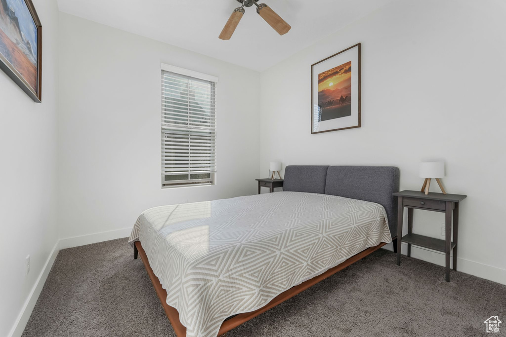 Carpeted bedroom with baseboards and ceiling fan
