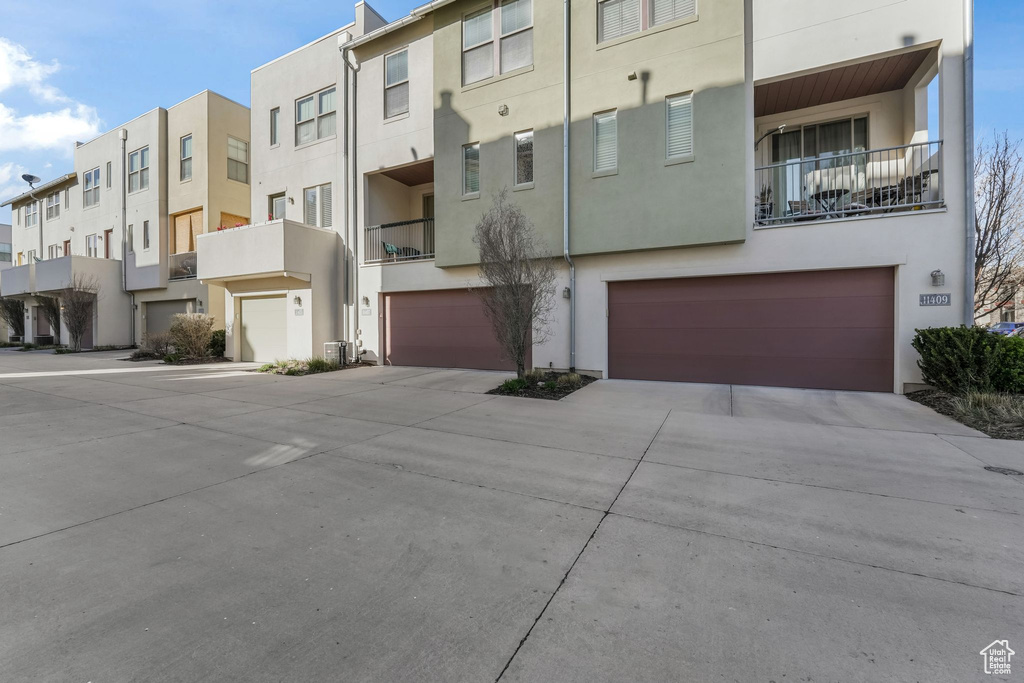 View of property featuring a residential view, driveway, and an attached garage