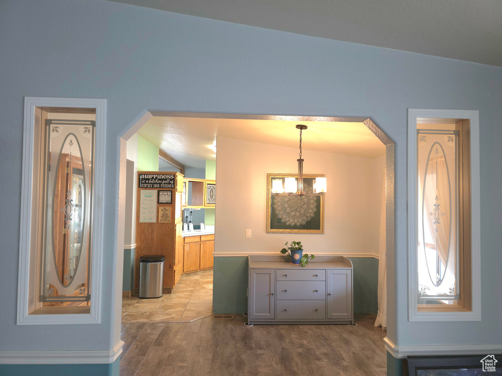 Corridor featuring wood finished floors, arched walkways, and baseboards
