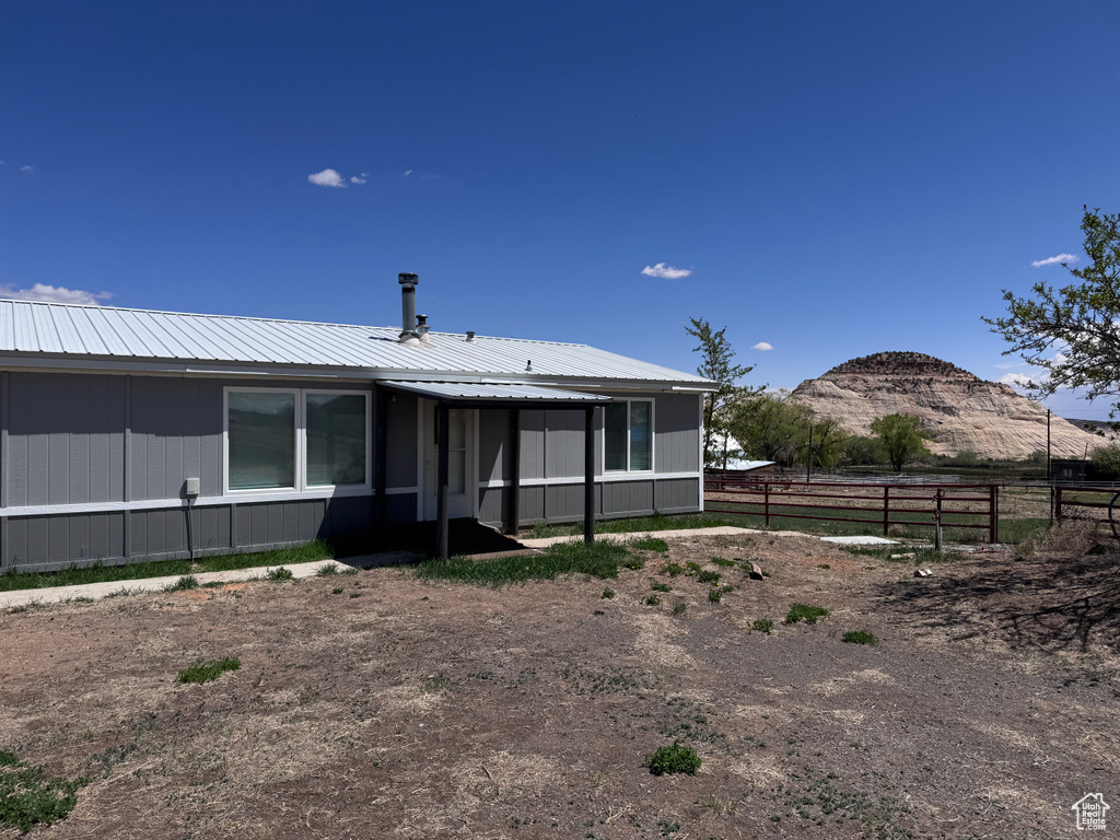 Back of property featuring fence and metal roof