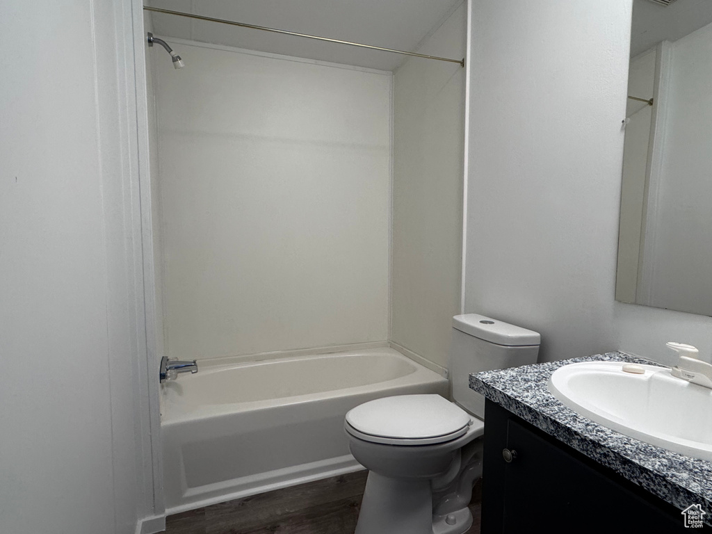 Full bathroom with  shower combination, wood finished floors, toilet, and vanity