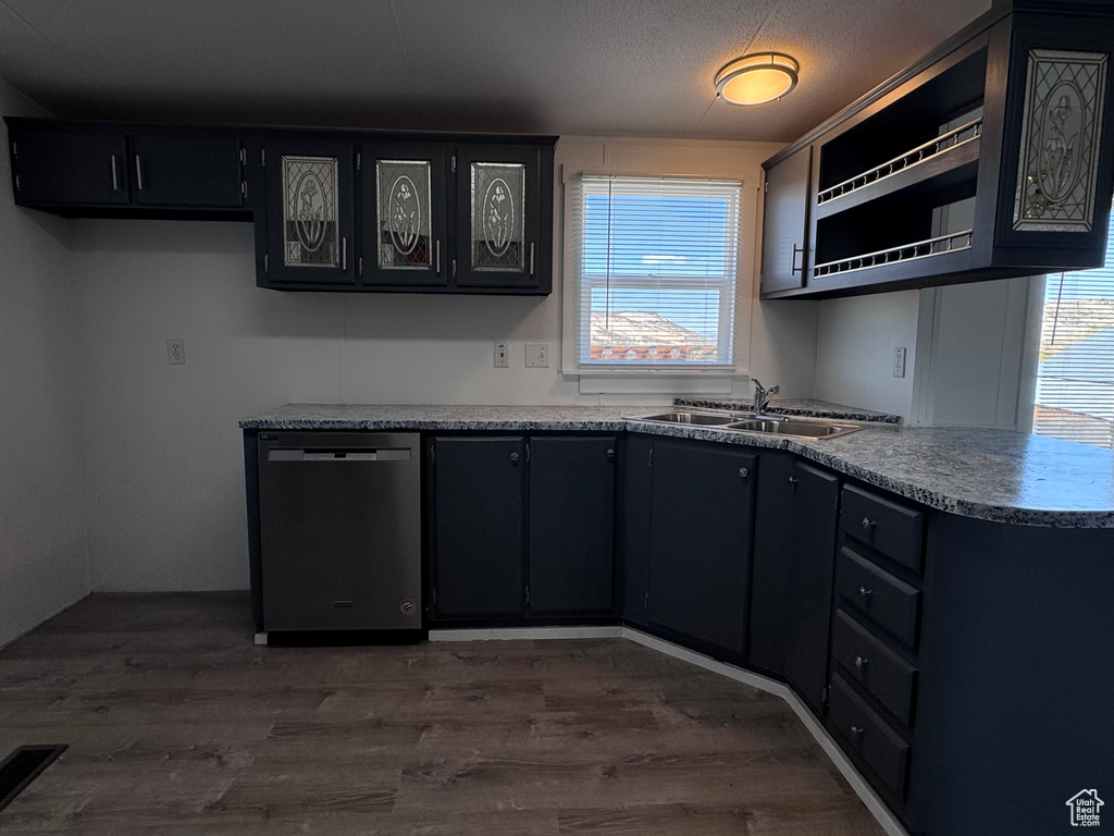 Kitchen featuring dishwasher, a sink, and dark cabinetry