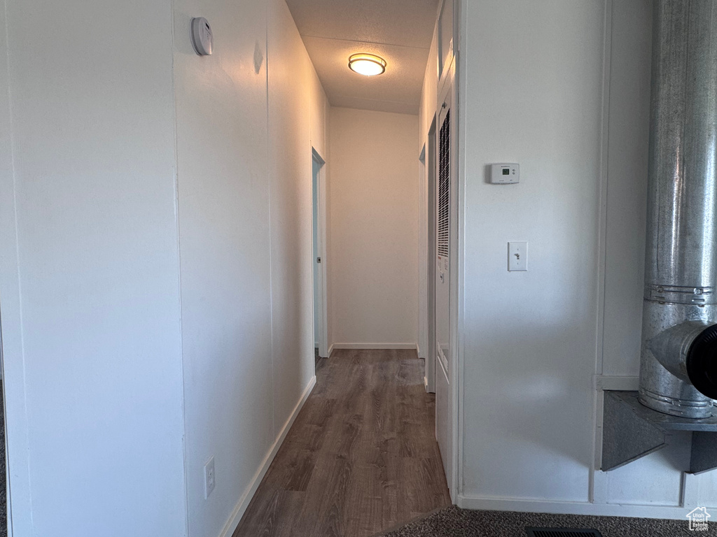 Corridor with wood finished floors and baseboards