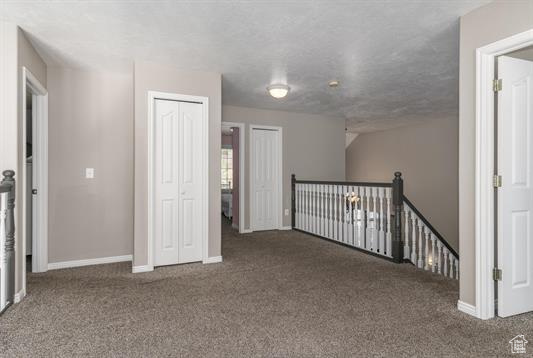 Interior space featuring baseboards, carpet flooring, and an upstairs landing