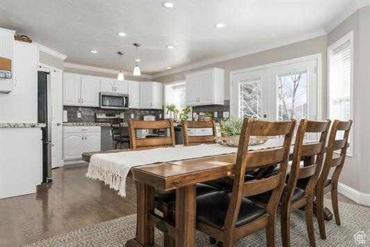 Dining space featuring crown molding, baseboards, recessed lighting, and wood finished floors