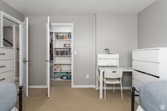 Bedroom with baseboards and light carpet