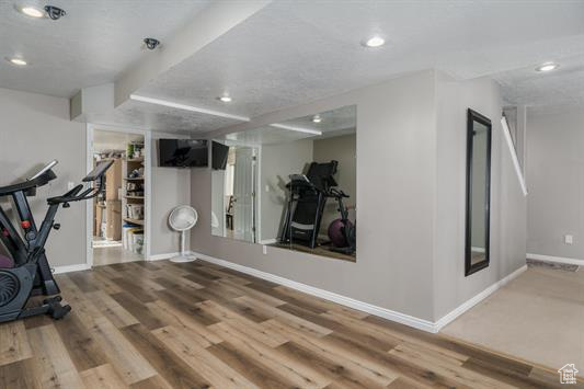 Exercise area featuring recessed lighting, baseboards, and wood finished floors