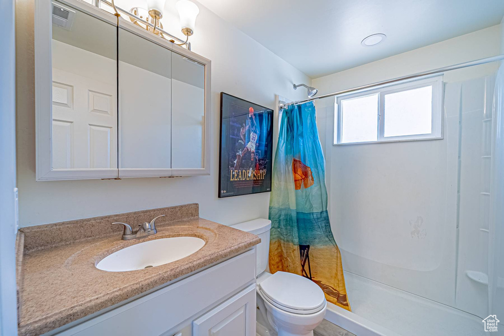 Bathroom with visible vents, toilet, a shower with shower curtain, and vanity