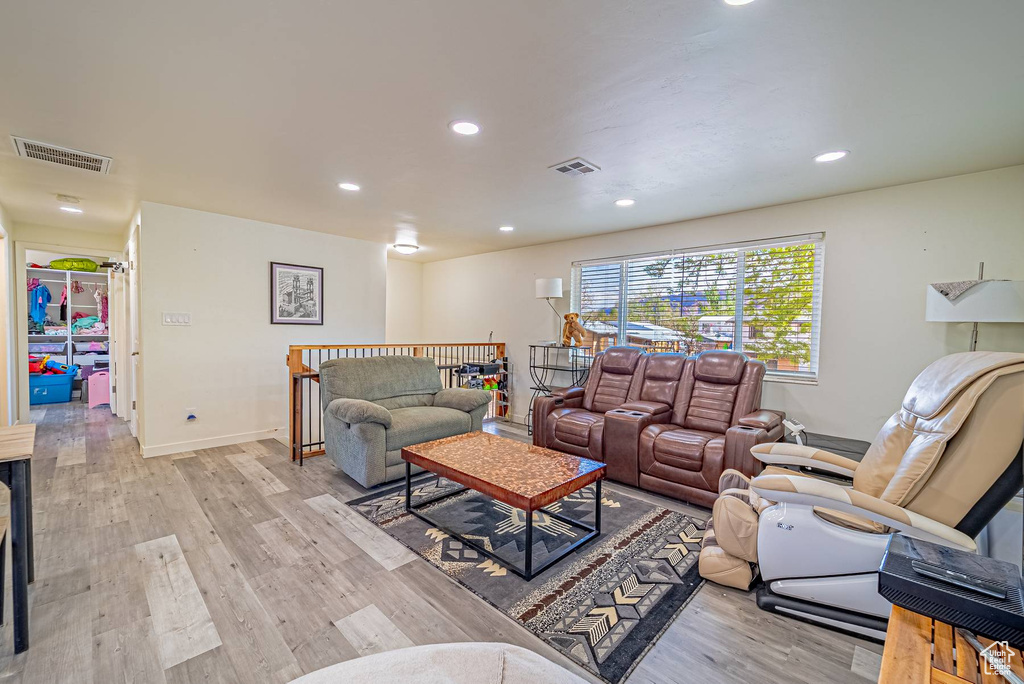 Living room with light wood finished floors, visible vents, and recessed lighting