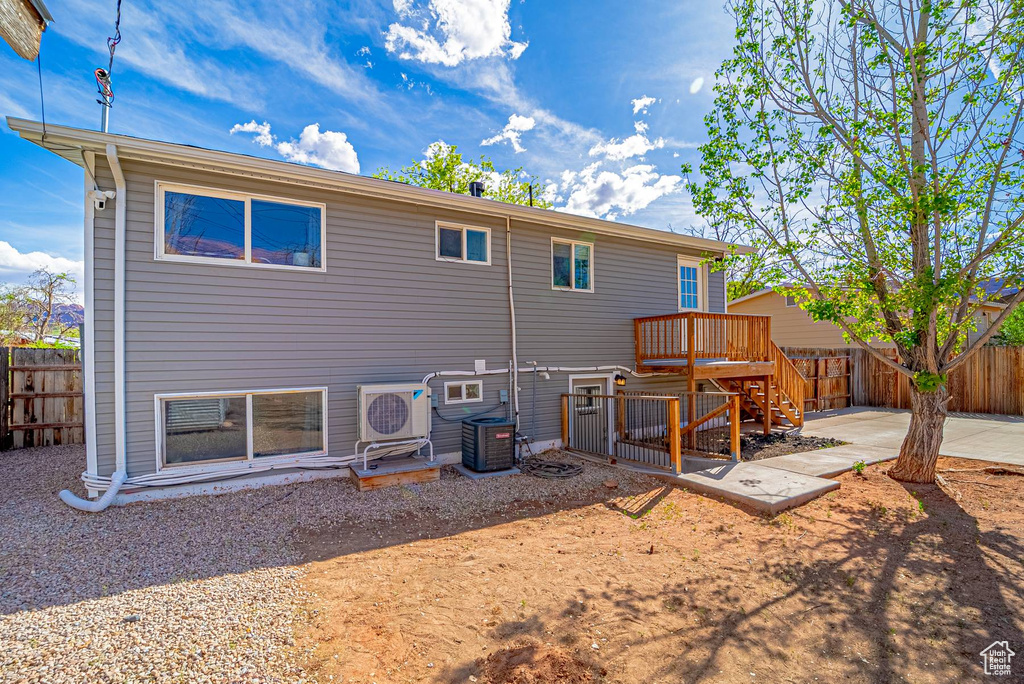 Rear view of house with a patio area, central air condition unit, a fenced backyard, and stairs