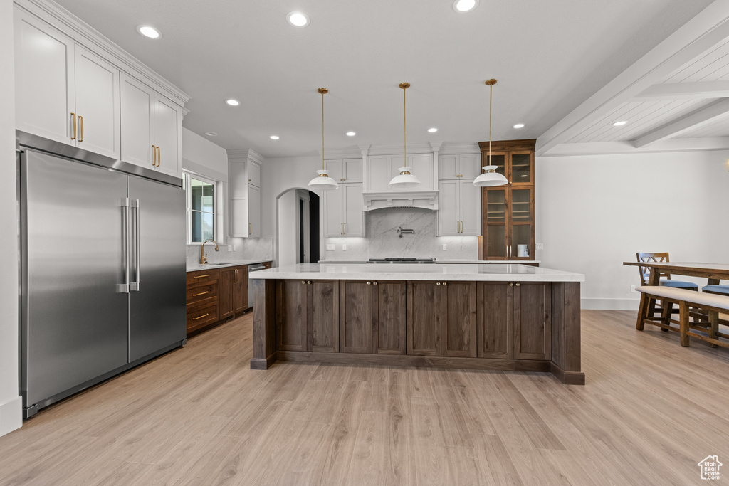 Kitchen with stainless steel appliances, light countertops, recessed lighting, tasteful backsplash, and light wood finished floors