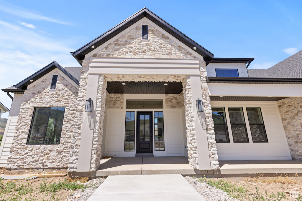 Entrance to property featuring a porch and stone siding