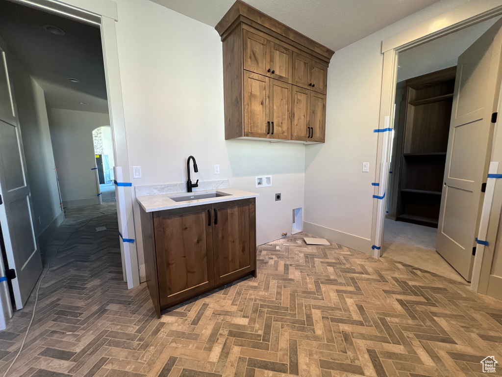 Laundry area featuring hookup for an electric dryer, cabinet space, hookup for a washing machine, and arched walkways