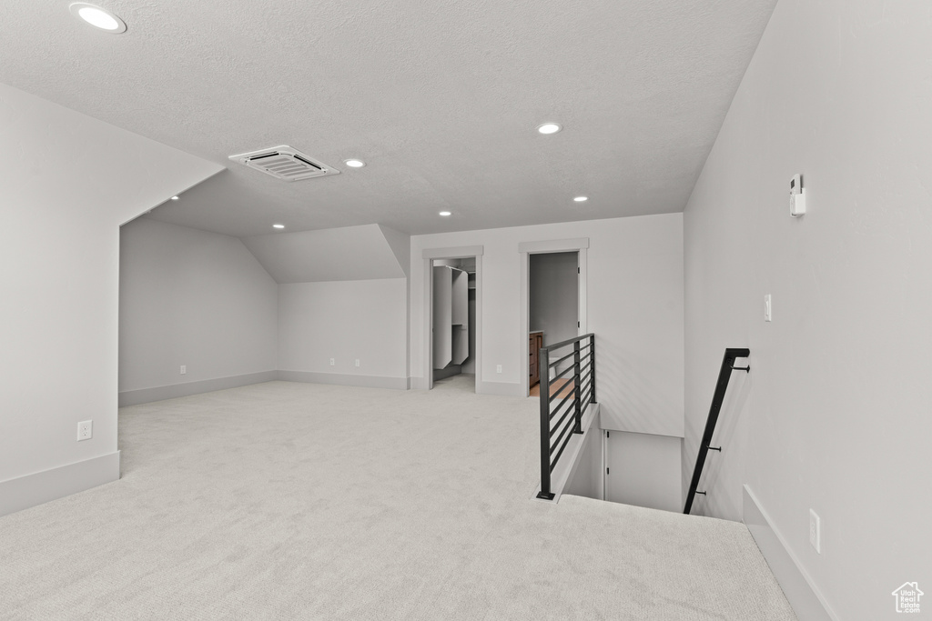Bonus room with recessed lighting, carpet floors, a textured ceiling, and vaulted ceiling