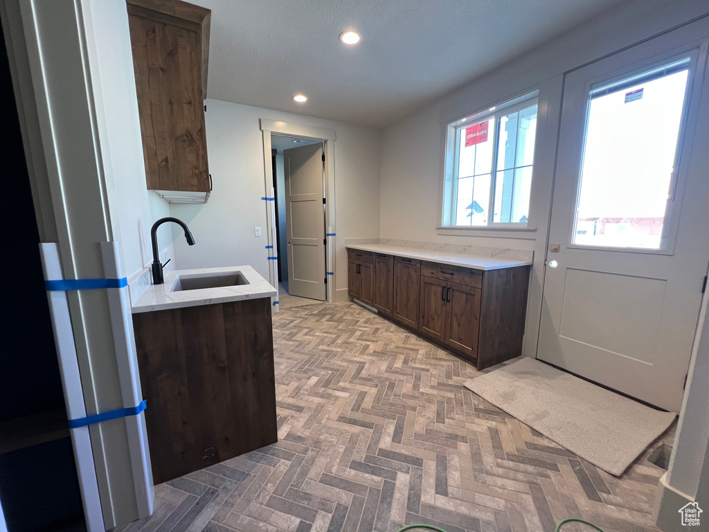 Kitchen with a sink, dark brown cabinetry, recessed lighting, and light countertops