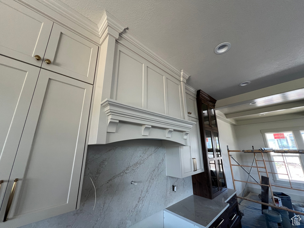 Kitchen featuring dark stone counters, recessed lighting, and white cabinets