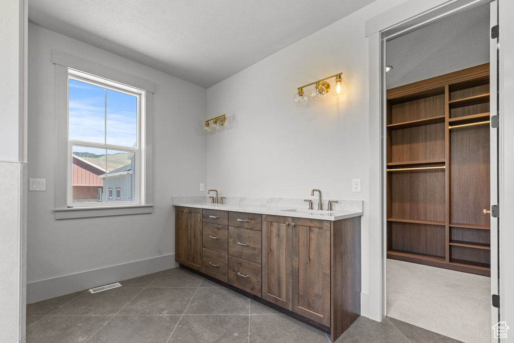 Full bathroom featuring double vanity and tile patterned flooring
