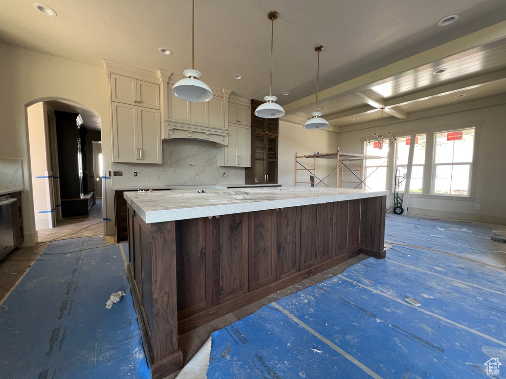 Kitchen featuring backsplash, recessed lighting, a large island, arched walkways, and pendant lighting