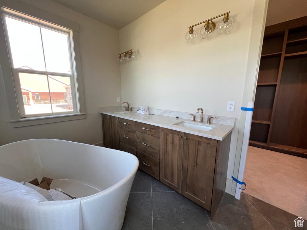 Full bathroom with a soaking tub, tile patterned floors, and double vanity