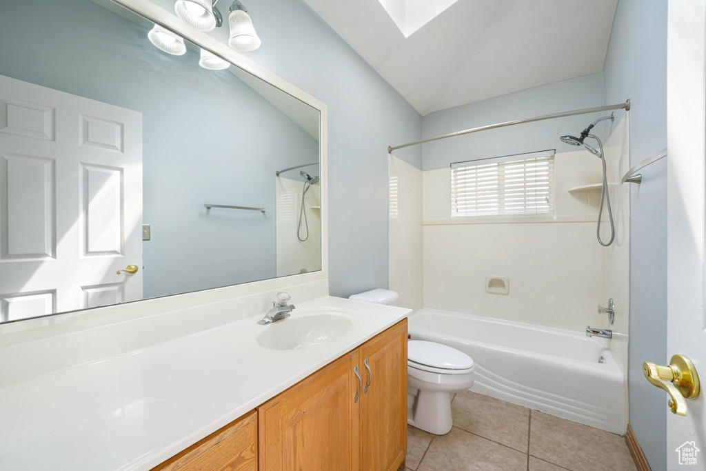 Bathroom featuring vanity, shower / washtub combination, tile patterned floors, toilet, and a skylight