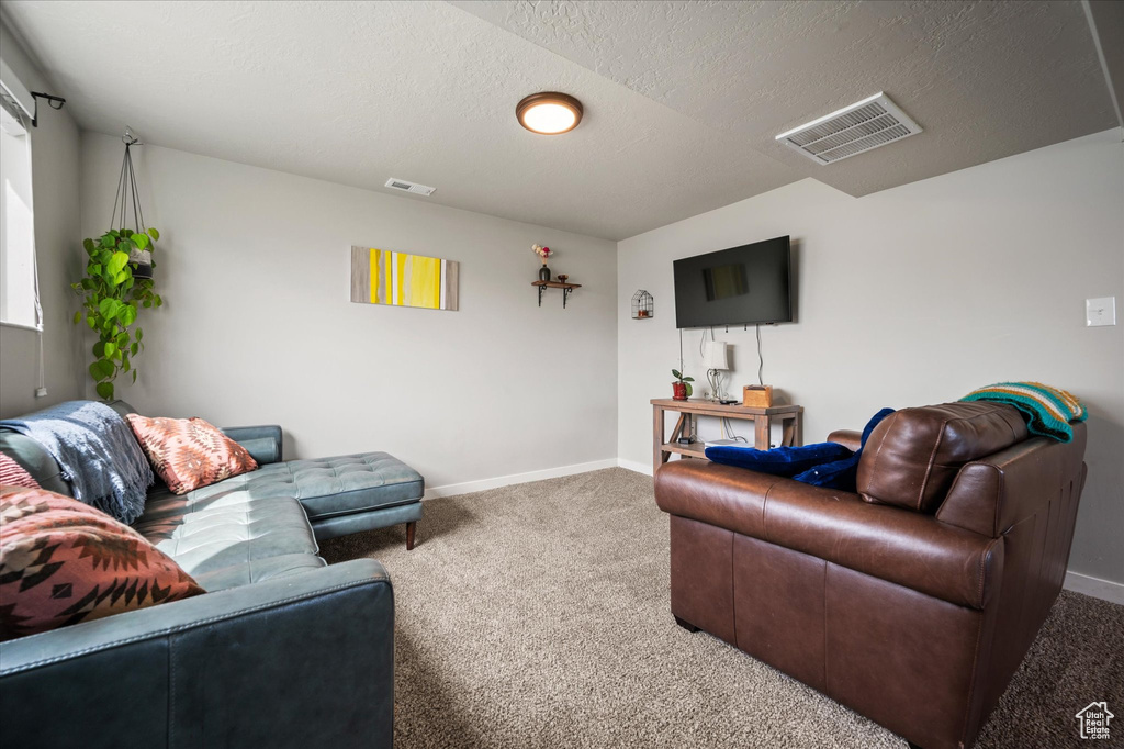 Living room featuring visible vents, baseboards, and carpet floors