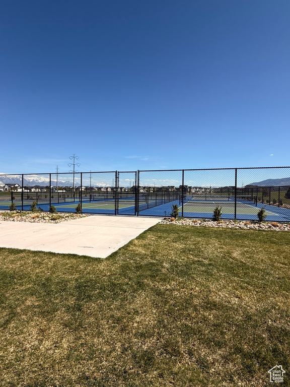 Surrounding community featuring a lawn, fence, and a tennis court