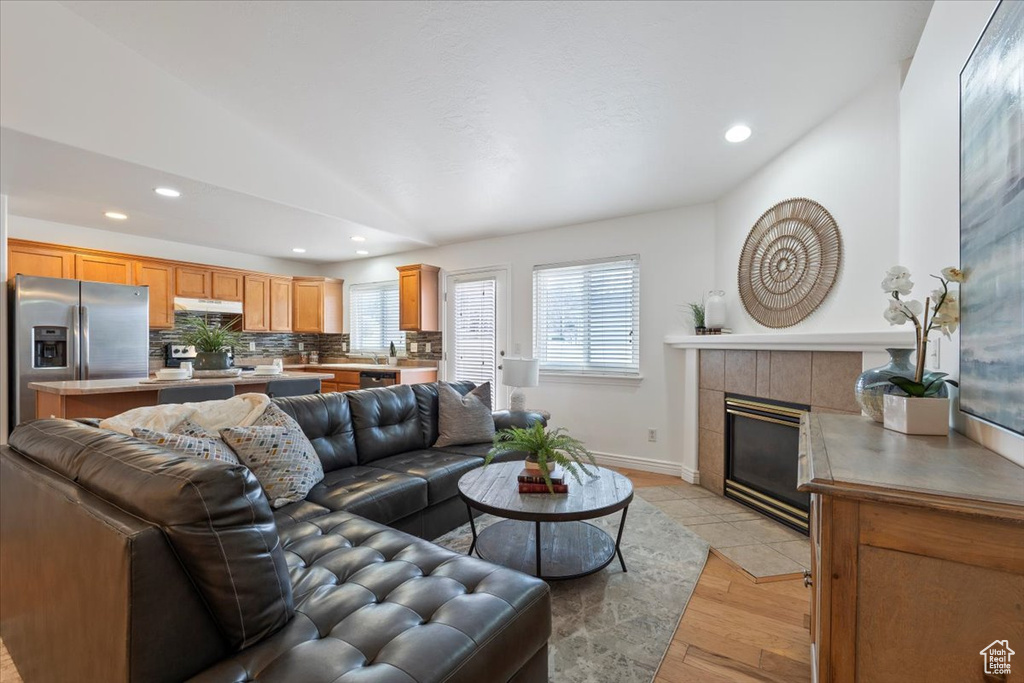 Living area with recessed lighting, a fireplace, light wood-type flooring, and baseboards