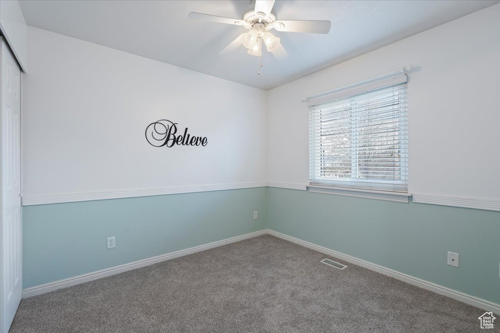 Spare room featuring ceiling fan, baseboards, visible vents, and carpet floors