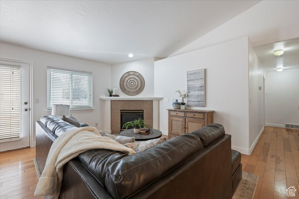 Living area with recessed lighting, a fireplace, light wood-style floors, and baseboards