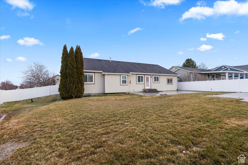 Back of house featuring a patio area, a fenced backyard, and a lawn
