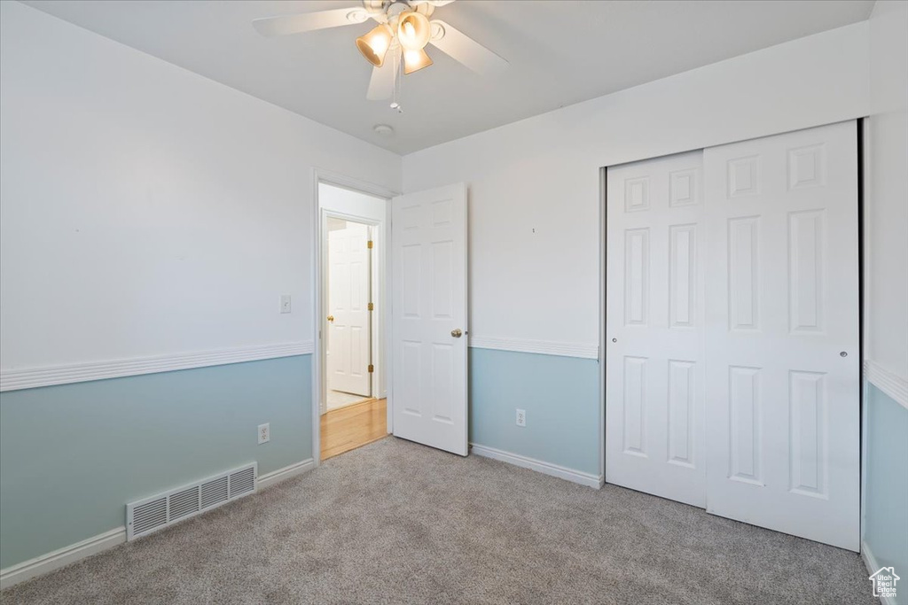 Unfurnished bedroom featuring visible vents, baseboards, a closet, a ceiling fan, and carpet flooring