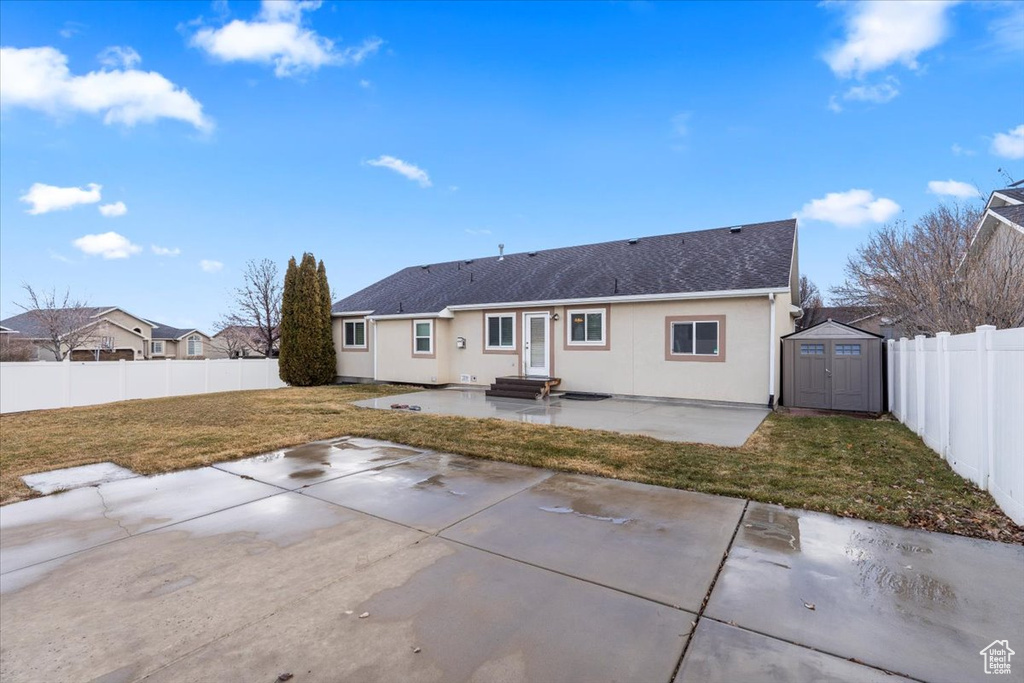 Rear view of property with a patio, an outdoor structure, entry steps, a storage shed, and a yard