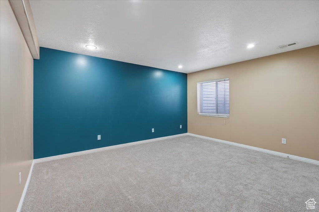 Empty room with baseboards, visible vents, and carpet floors