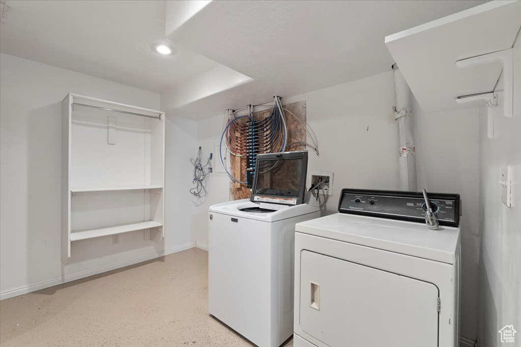 Clothes washing area featuring washing machine and clothes dryer, recessed lighting, laundry area, and baseboards