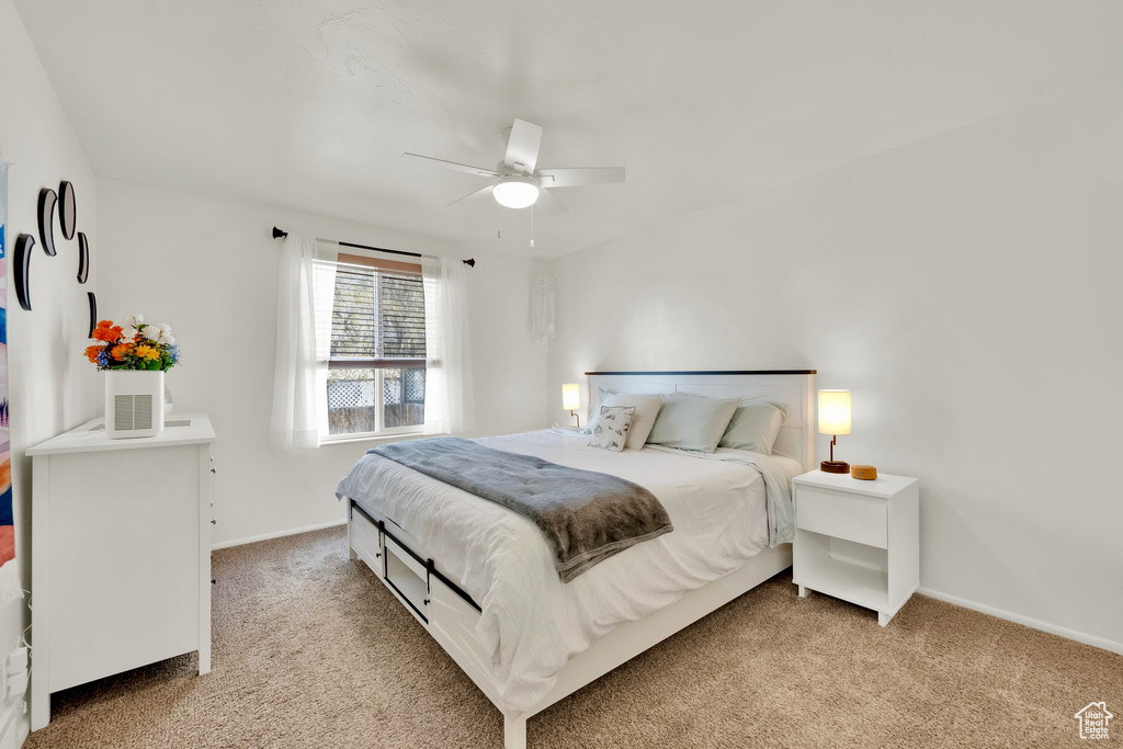 Bedroom with baseboards, ceiling fan, and light colored carpet