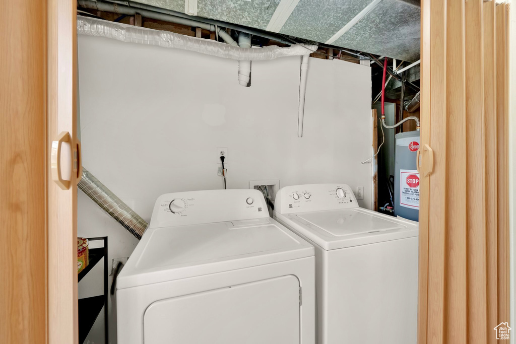 Laundry area featuring water heater, washing machine and dryer, and laundry area