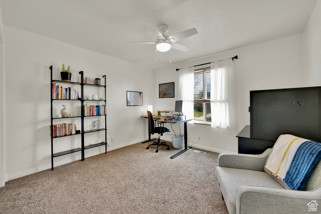 Carpeted office with baseboards, a ceiling fan, and visible vents