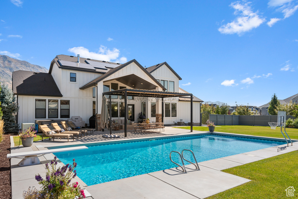 View of pool featuring a lawn, a patio, fence, a mountain view, and a fenced in pool