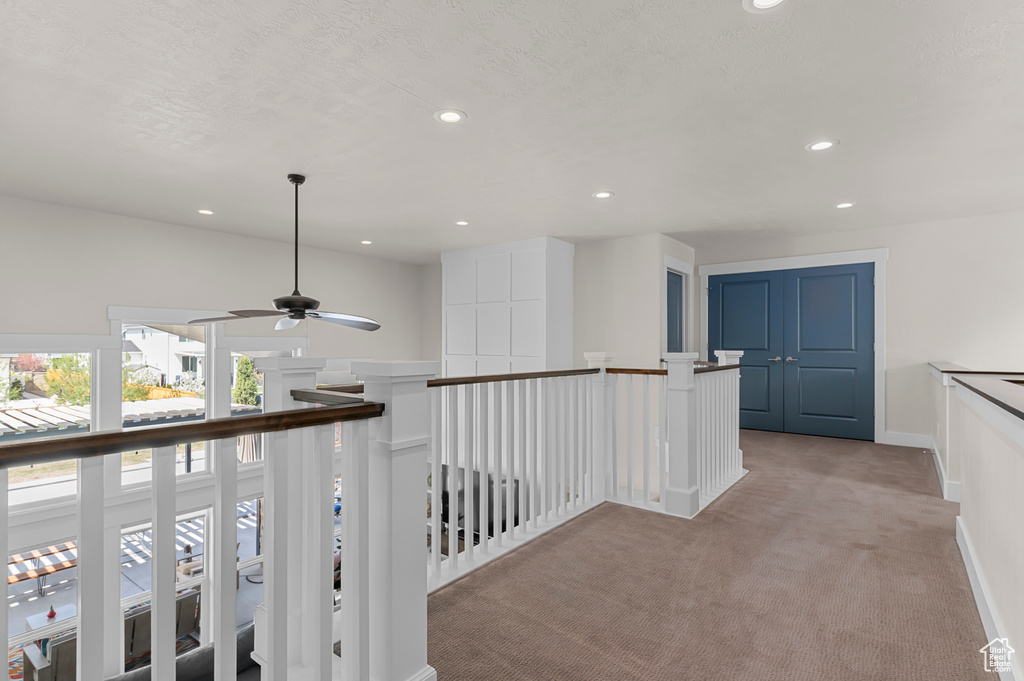 Hall with light carpet, recessed lighting, and an upstairs landing