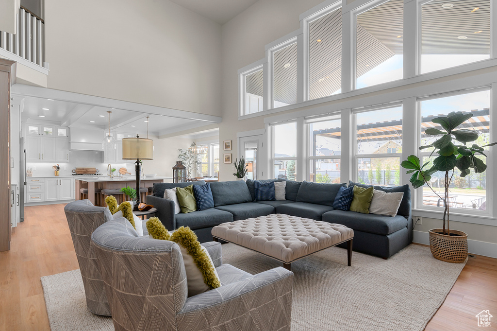 Living area featuring light wood-type flooring and a high ceiling