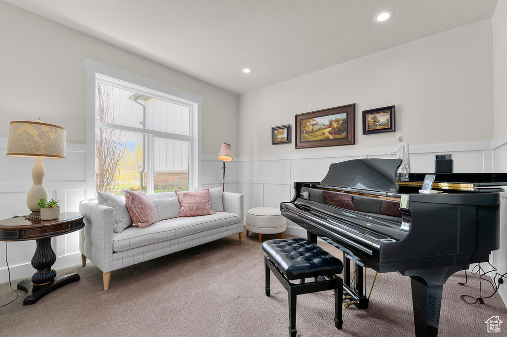 Living area with a decorative wall, carpet, and a wainscoted wall